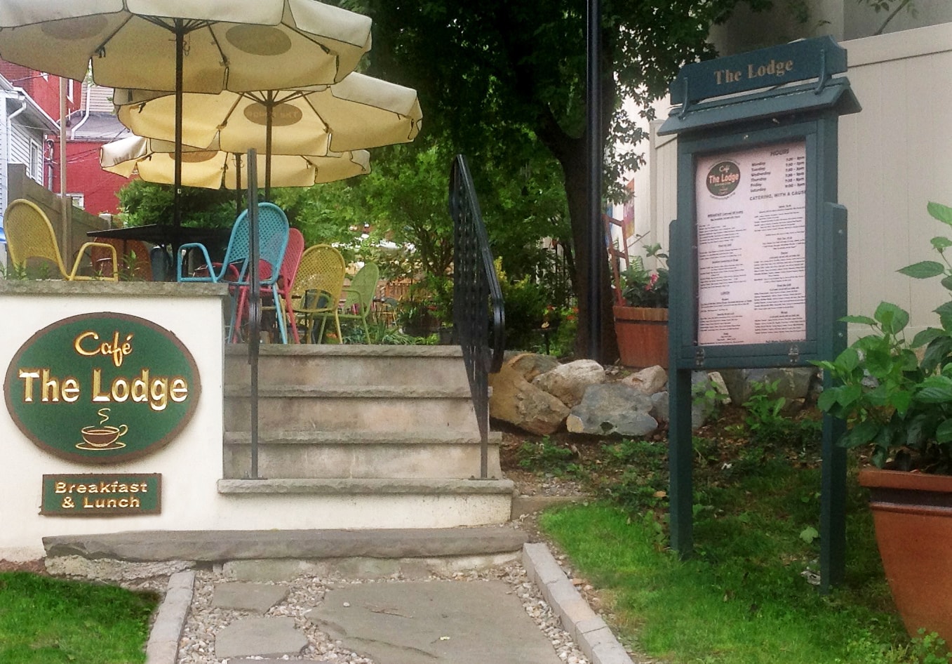 Café The Lodge outdoor garden seating area with colorful chairs and umbrellas
